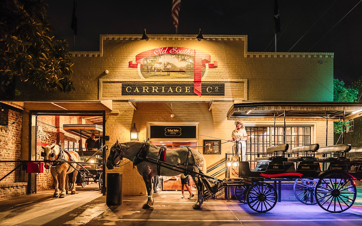Charleston horse-drawn carriage at Old South Carriage Co. at night.