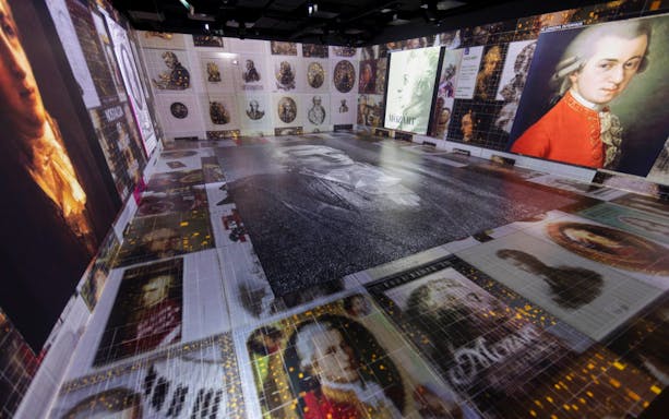Guests explore digital displays at Mythos Mozart Immersive Experience in Vienna.