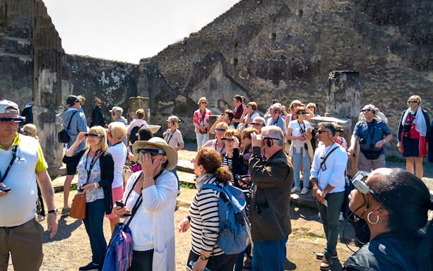 Visitors using augmented reality glasses at Pompeii ruins.