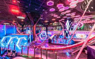 Roller coaster and neon lights inside Doha Quest Theme Park.