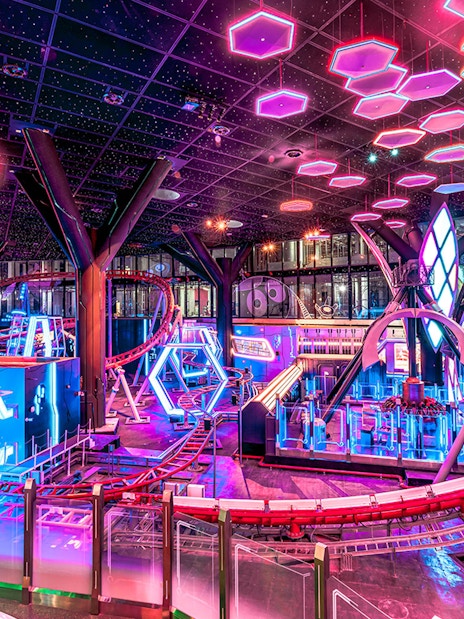 Roller coaster and neon lights inside Doha Quest Theme Park.