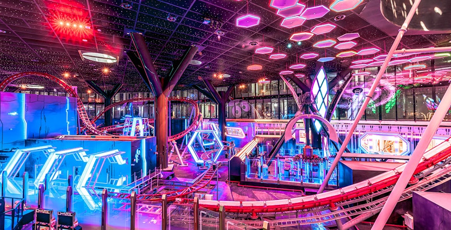 Roller coaster and neon lights inside Doha Quest Theme Park.