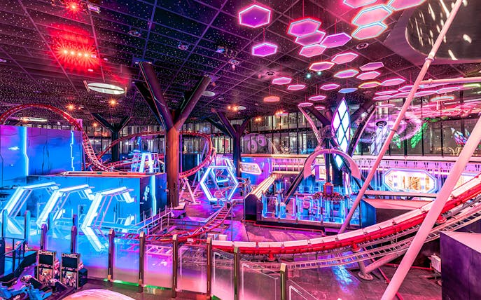 Roller coaster and neon lights inside Doha Quest Theme Park.