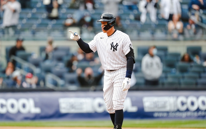 Baseball player in Yankees uniform pointing during a game at Yankee Stadium.