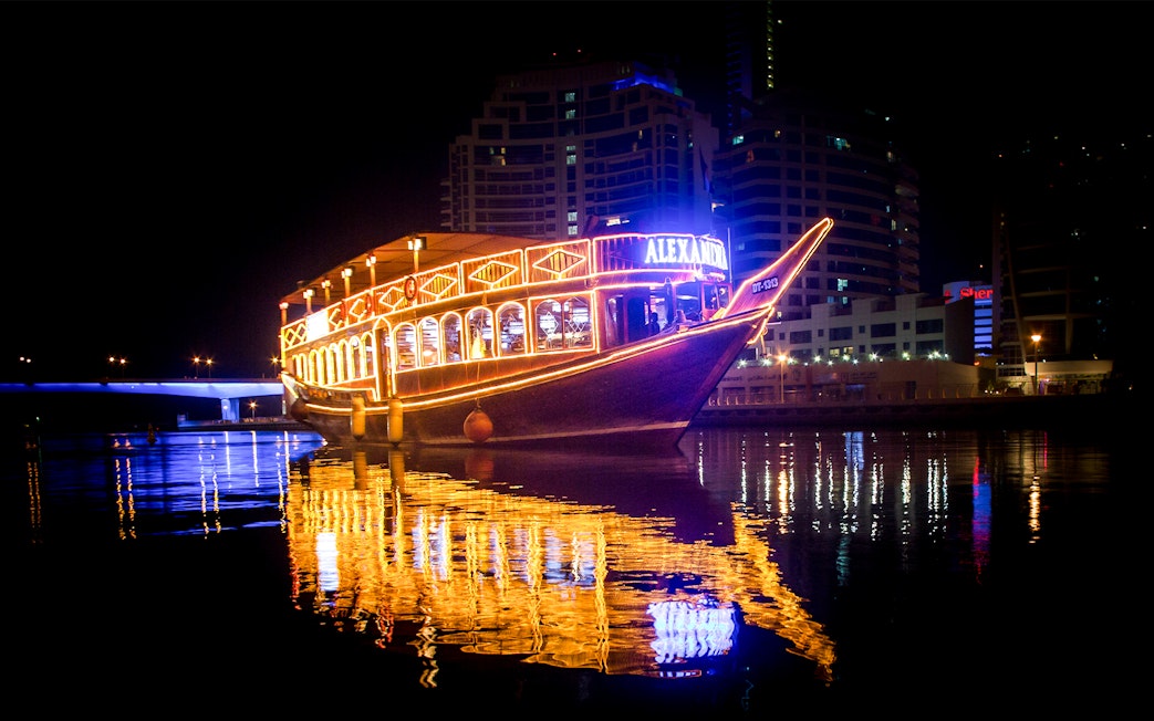 Alexandra VIP Dhow Cruise illuminated at night on Dubai Marina waters.