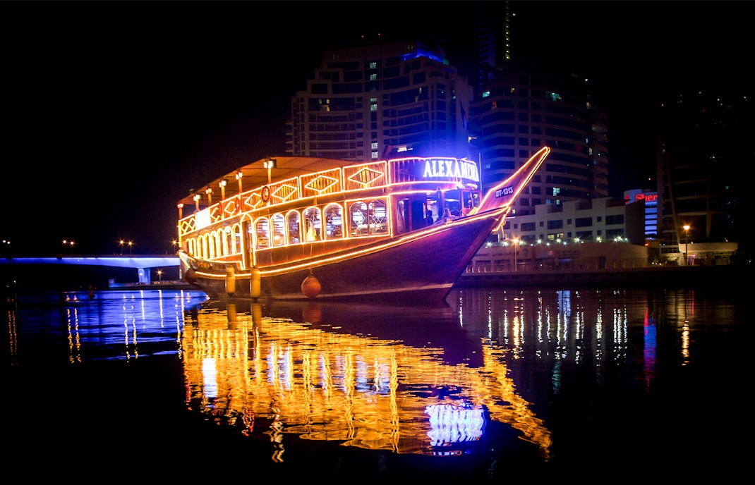 Alexandra VIP Dhow Cruise illuminated at night on Dubai Marina waters.