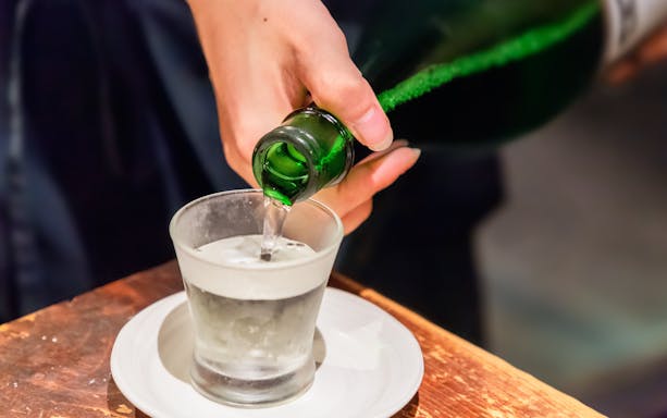 Pouring sake into a glass at a Japanese restaurant.