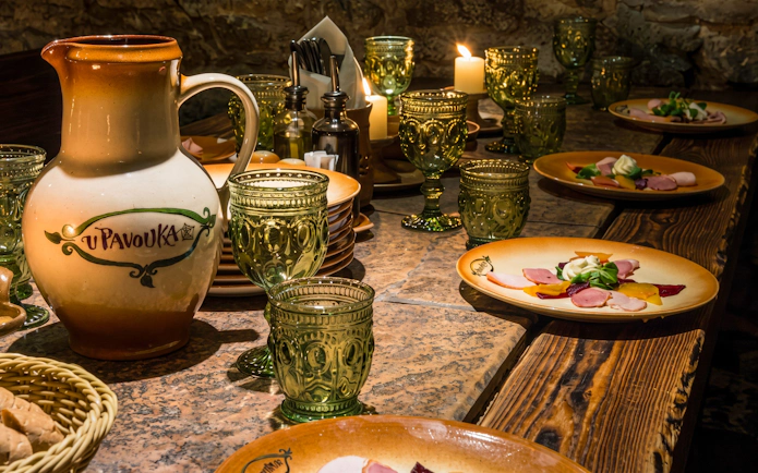Medieval dinner table setting with ceramic jug and plates in Prague.