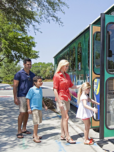 Family boarding a green trolley for the Day and Night Combo Tour of Niagara Falls, Canada.