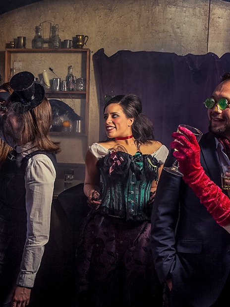 Visitors toasting drinks in a themed bar at London Dungeon.