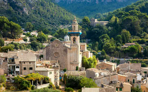 Valldemossa Charterhouse surrounded by village and mountains in Mallorca, Spain.