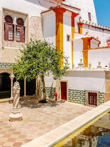 Sintra National Palace central courtyard with tree and bathing cave.