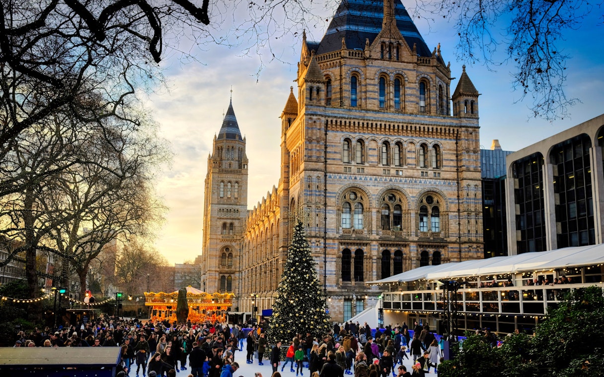 Crowd ice skating by a Christmas tree at the Natural History Museum in London.
