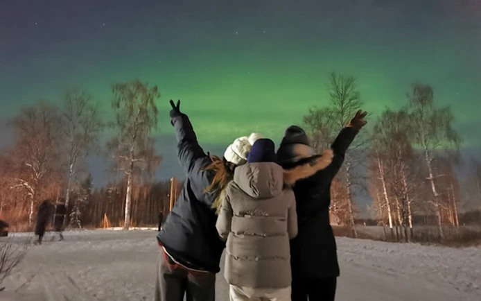 Friends watching northern lights in Lapland.