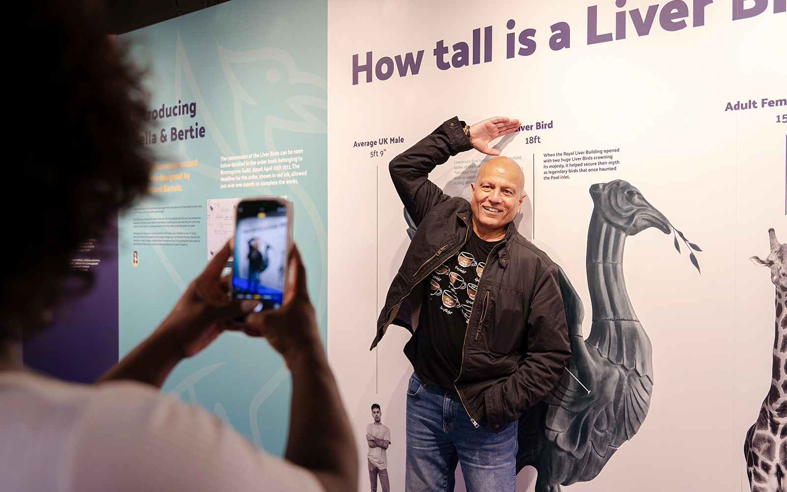 Guest posing with Liver Bird height display inside Royal Liver Building.