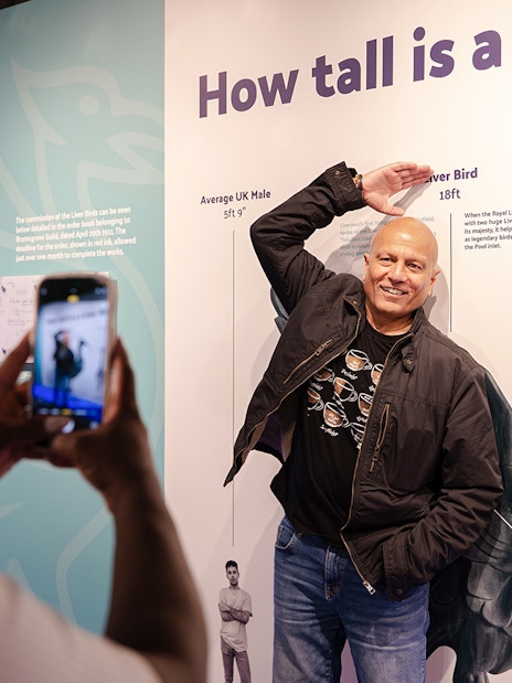 Guest posing with Liver Bird height display inside Royal Liver Building.