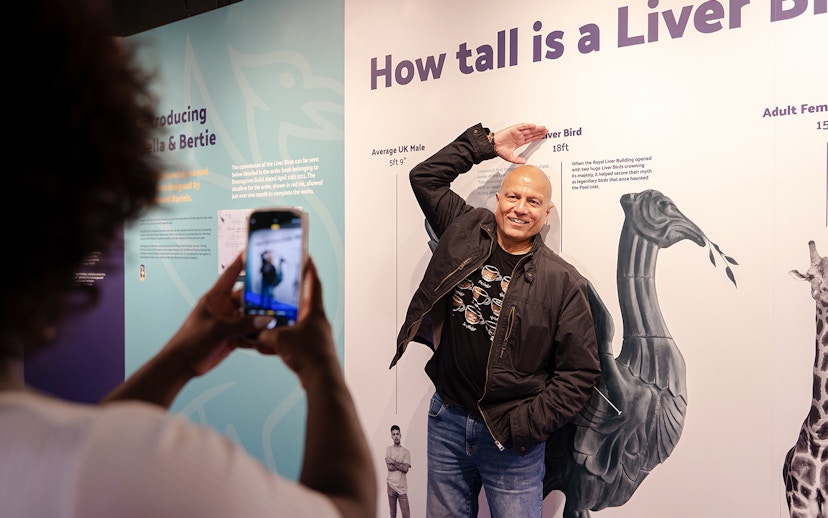 Guest posing with Liver Bird height display inside Royal Liver Building.