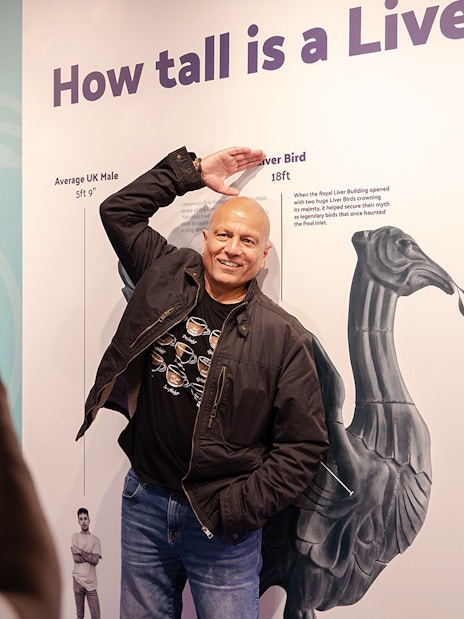 Guest posing with Liver Bird height display inside Royal Liver Building.