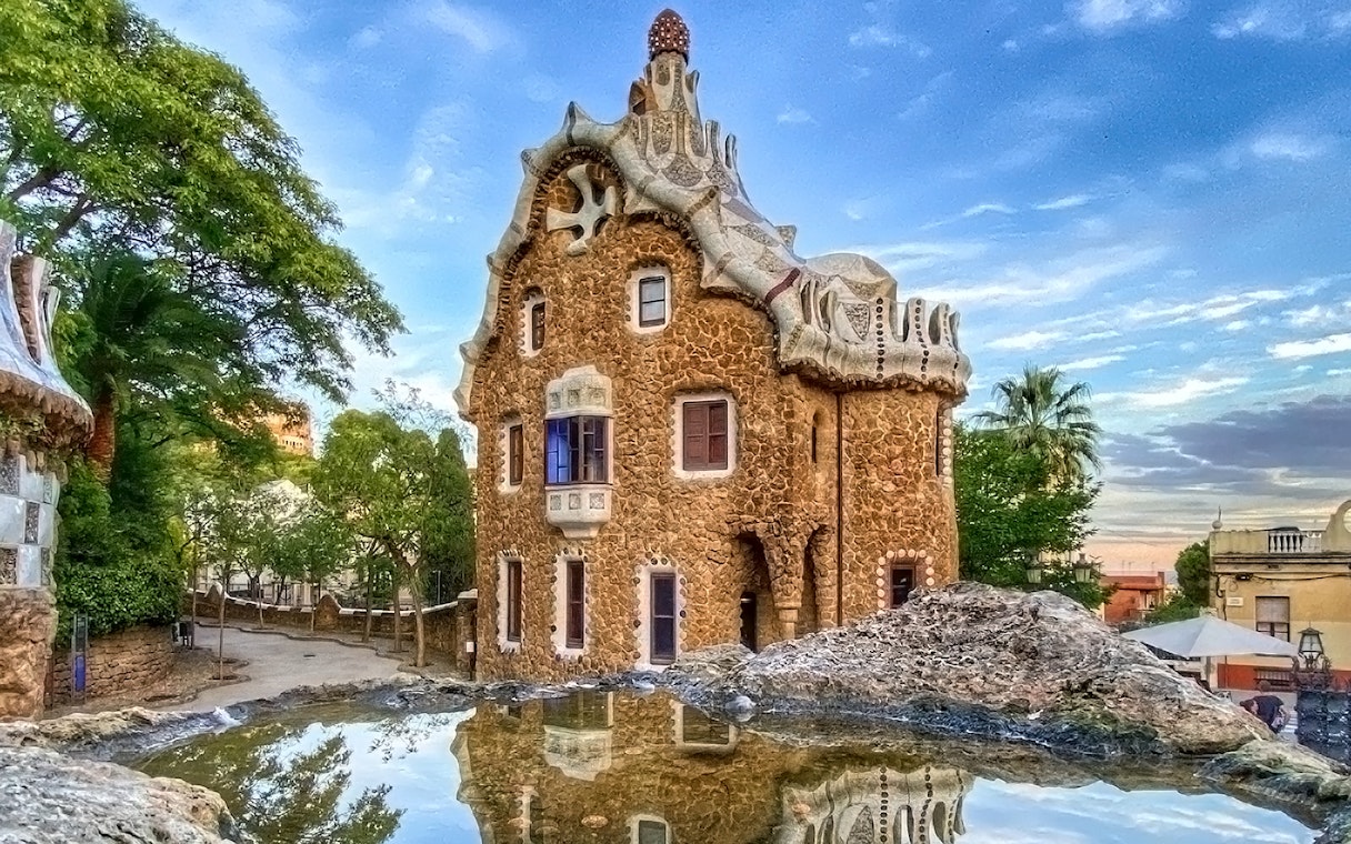 Park Güell's unique stone building with mosaic roof in Barcelona.
