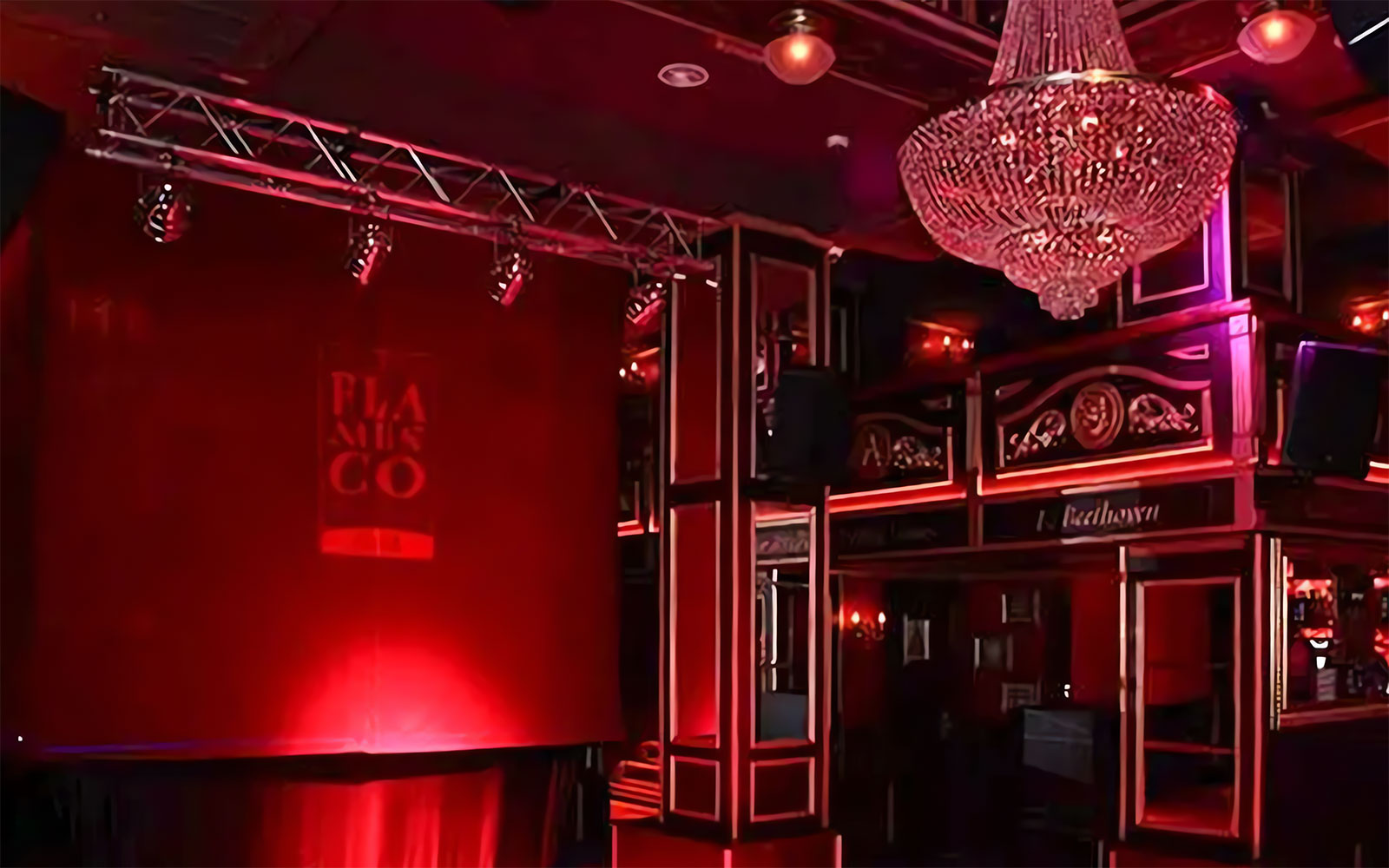 Flamenco stage with red lighting and chandelier at Málaga Club.