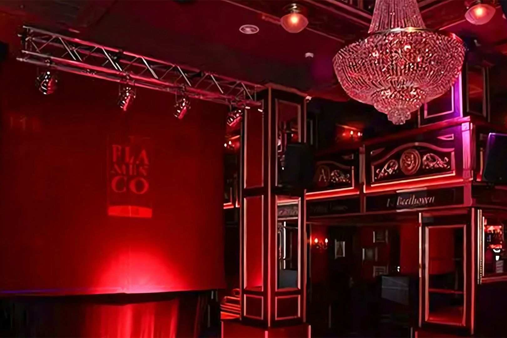 Flamenco stage with red lighting and chandelier at Málaga Club.