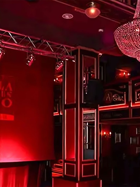 Flamenco stage with red lighting and chandelier at Málaga Club.