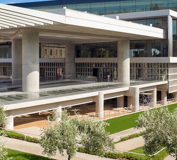 Acropolis Museum exterior with modern architecture and surrounding greenery in Athens, Greece.