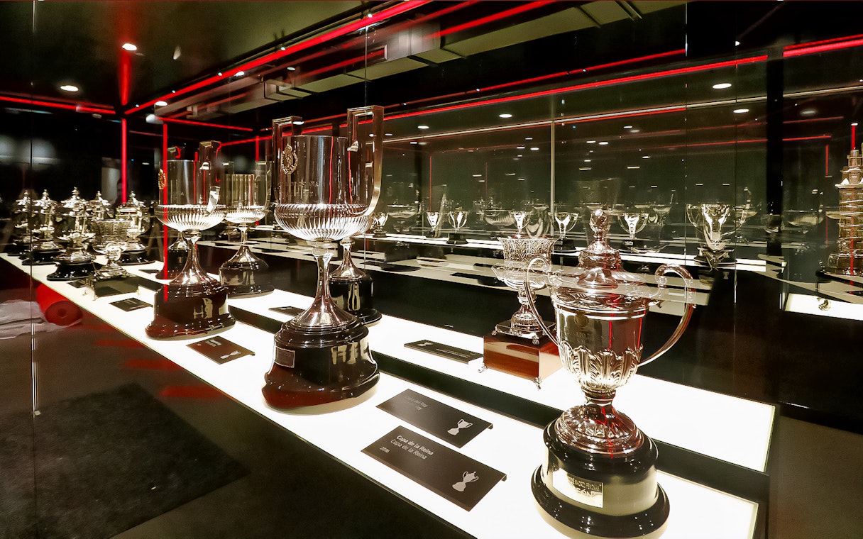 Trophies displayed in Atletico de Madrid Stadium Museum exhibit.