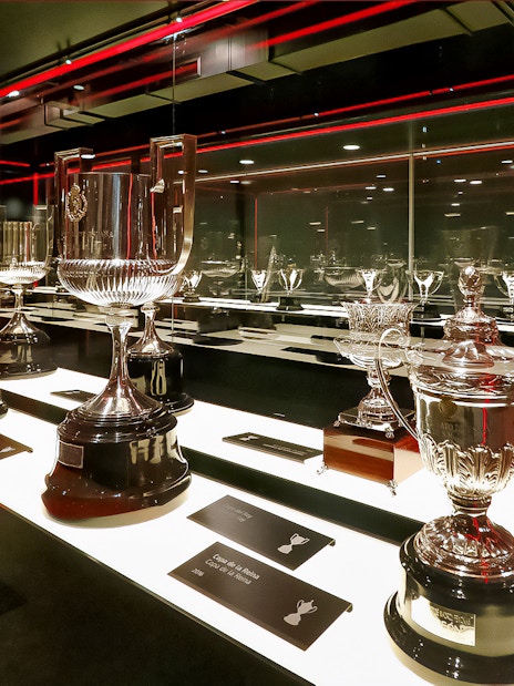 Trophies displayed in Atletico de Madrid Stadium Museum exhibit.