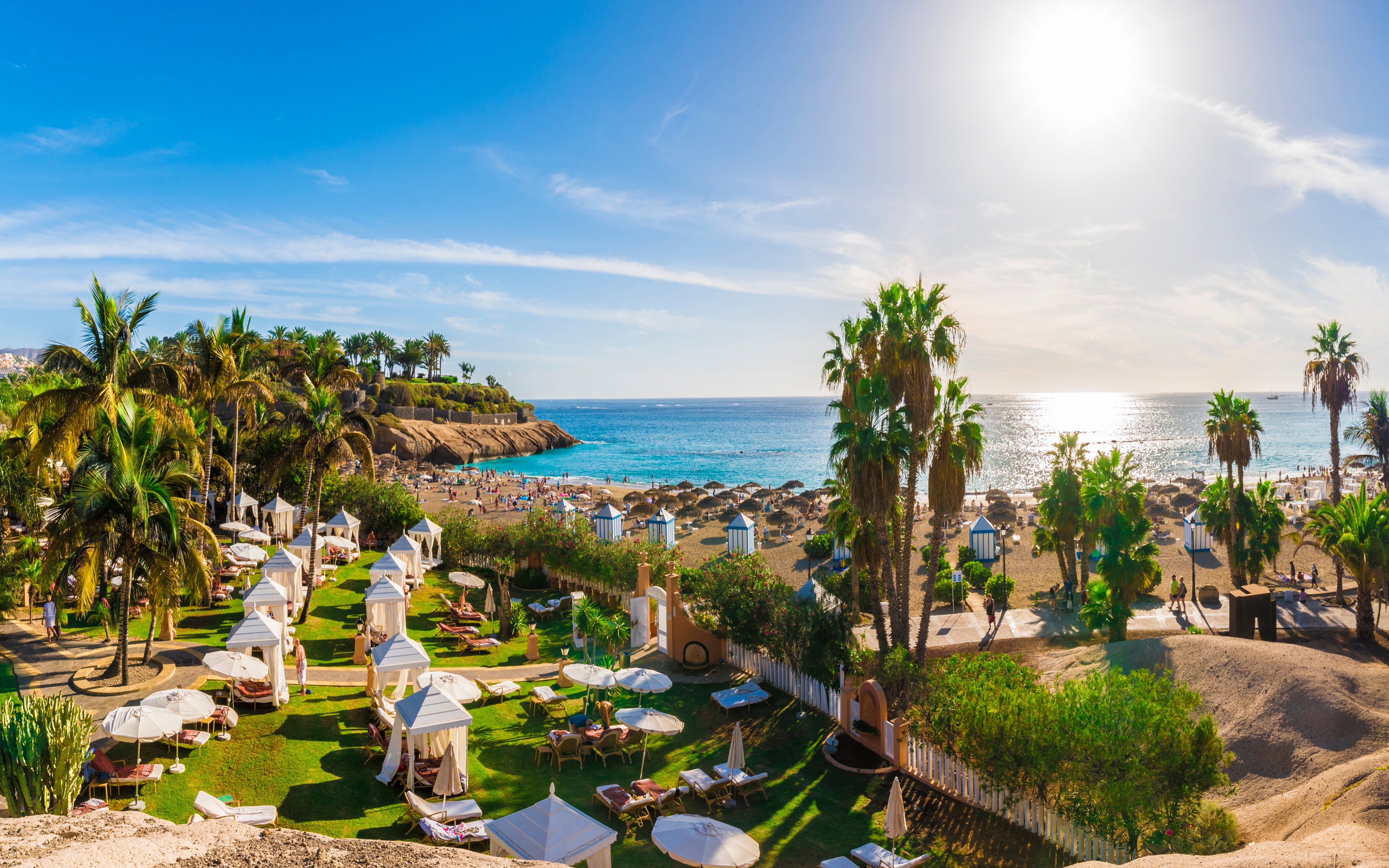 El Duque beach with palm trees and sun loungers, Costa Adeje, Tenerife, Canary Islands.