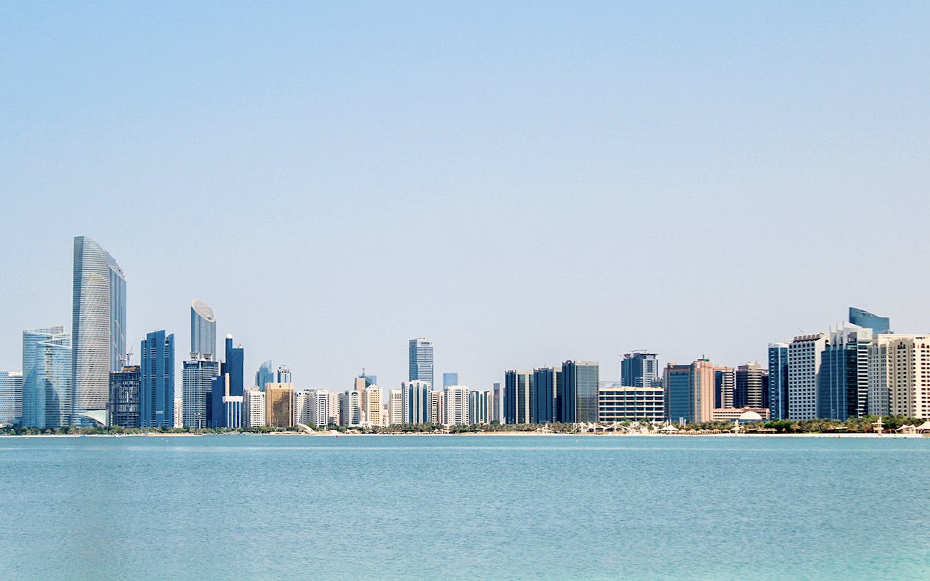 Abu Dhabi skyline with modern skyscrapers viewed from the water.