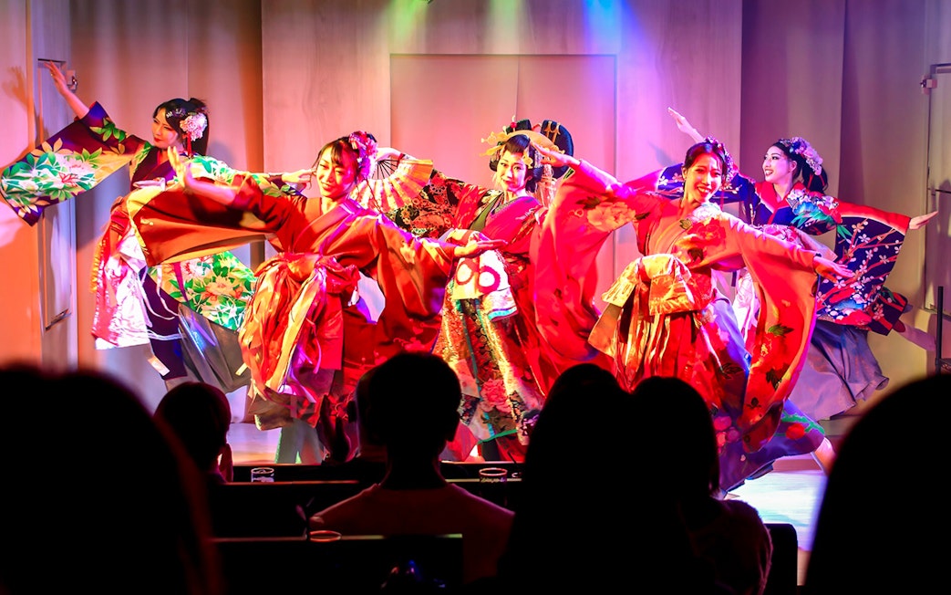Performers in traditional kimonos on stage at a Japanese cabaret theatre in Tokyo.