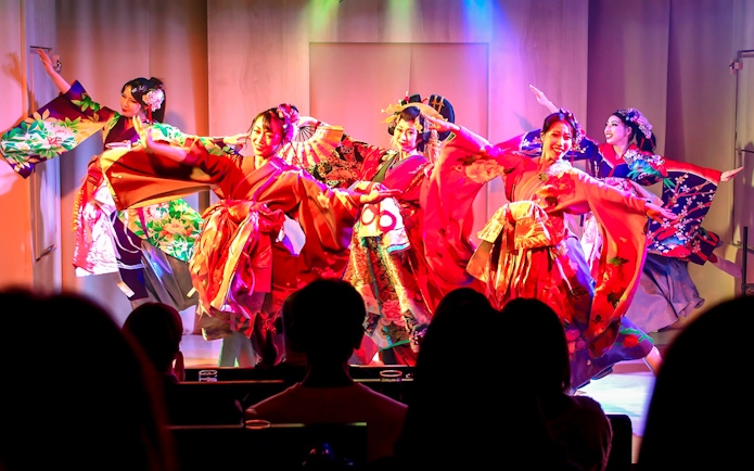 Performers in traditional kimonos on stage at a Japanese cabaret theatre in Tokyo.