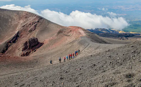 Group hiking along Mount Etna's volcanic ridge during a guided trek.