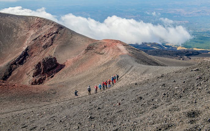 Group hiking along Mount Etna's volcanic ridge during a guided trek.