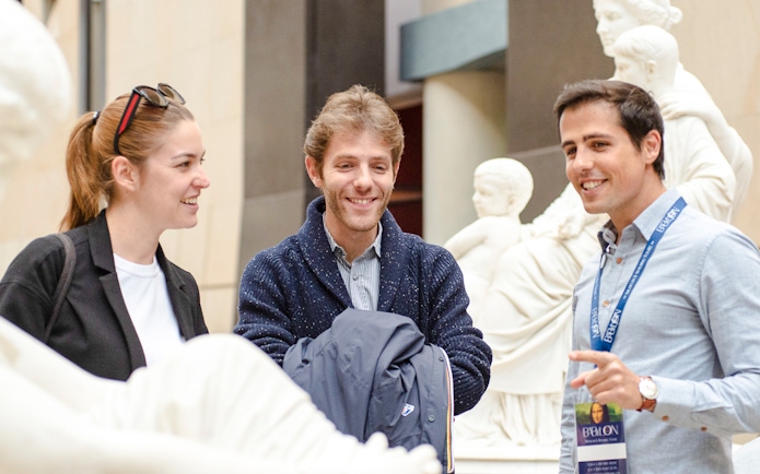 Guide with tourists inside Orsay Museum, France, discussing sculptures.