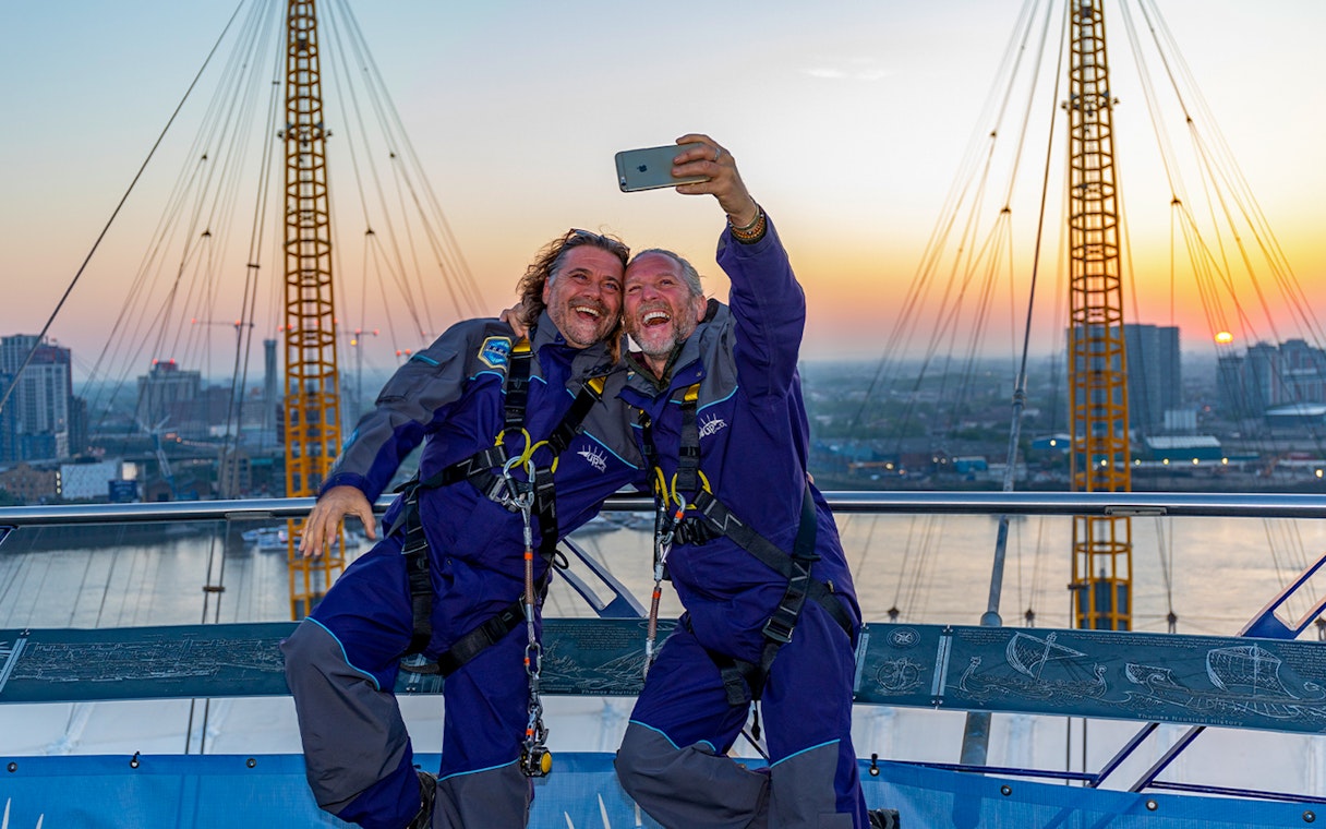 Guests taking a selfie on the O2 roof at sunset in London.