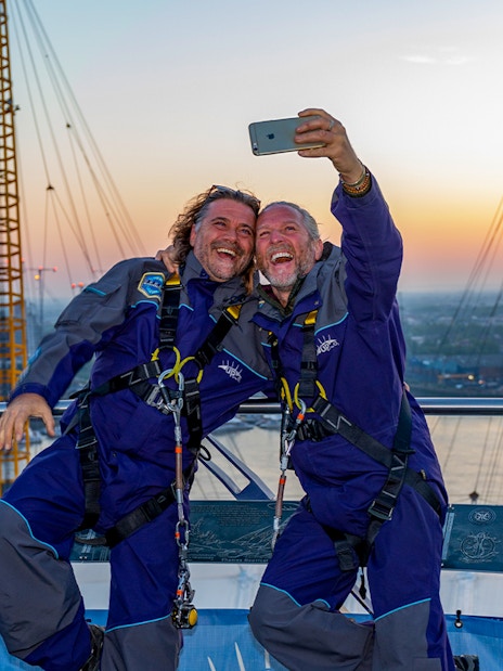 Guests taking a selfie on the O2 roof at sunset in London.