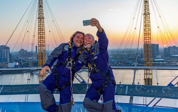 Guests taking a selfie on the O2 roof at sunset in London.