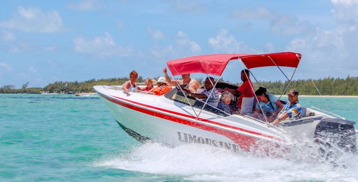 Speedboat with passengers on turquoise waters near Ile Aux Cerf, Mauritius.