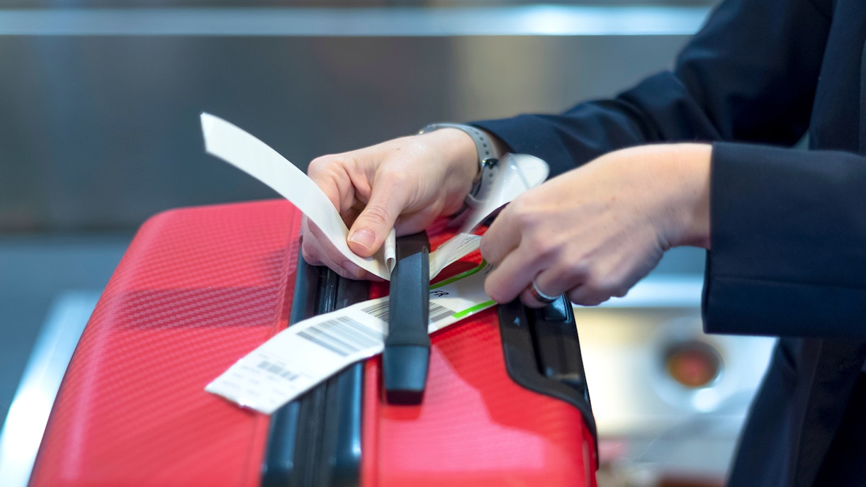 Anbringen eines Gepäckanhängers am Koffer am Flughafen Incheon
