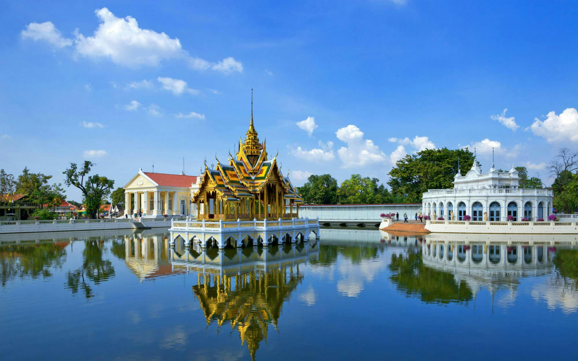 Bang Pa-In Royal Palace pavilion and surrounding buildings reflected in a serene lake.