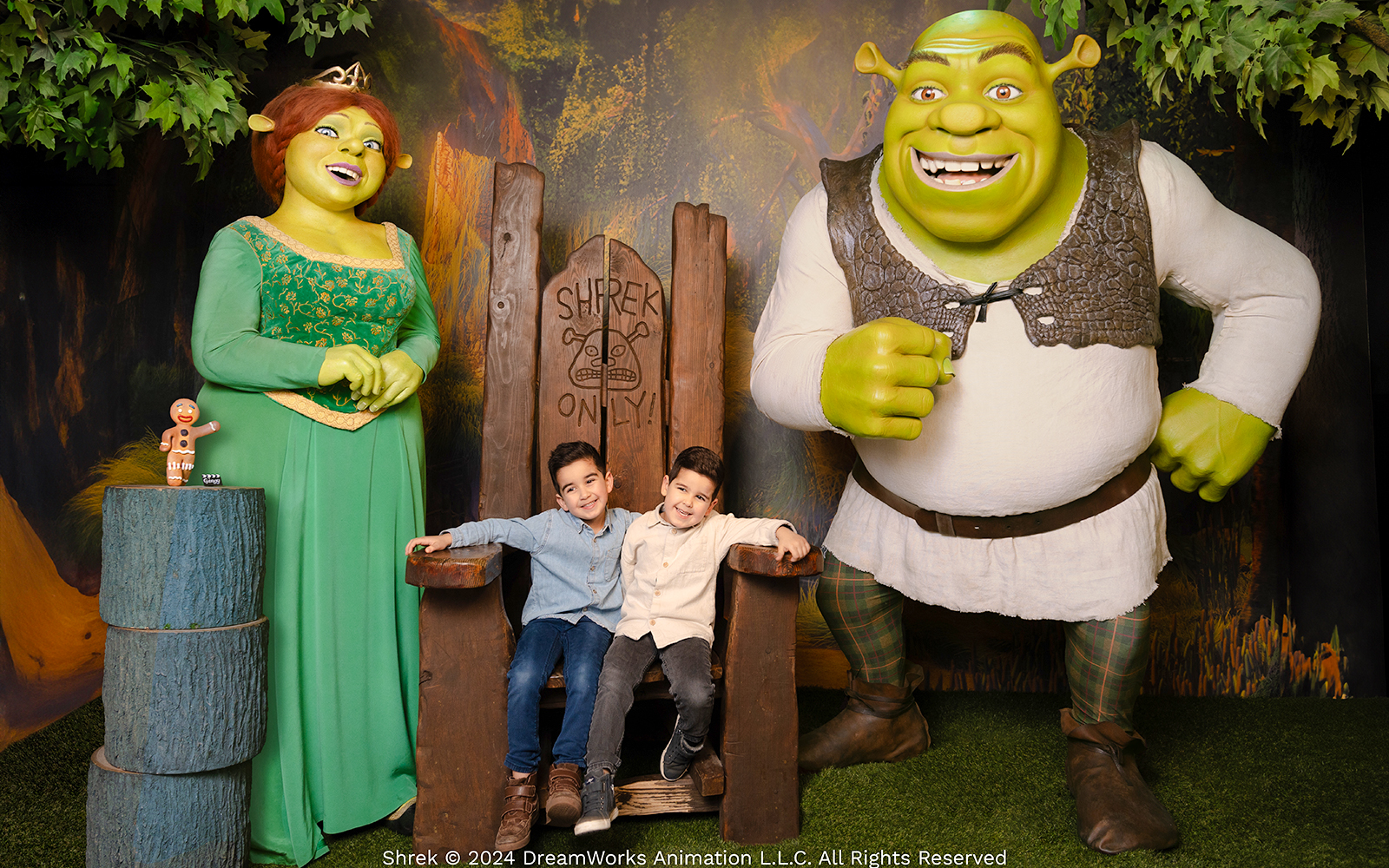Shrek and Fiona wax figures with children at Madame Tussauds Amsterdam.