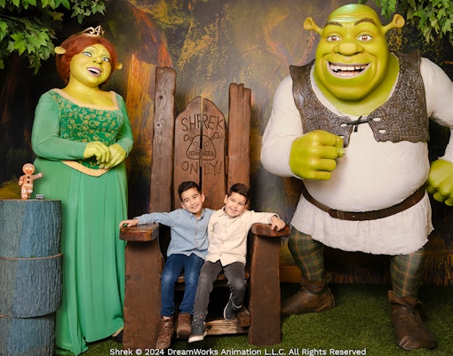 Shrek and Fiona wax figures with children at Madame Tussauds Amsterdam.