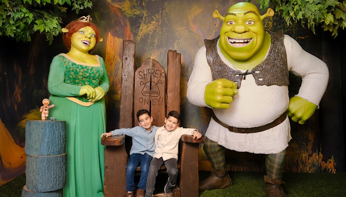 Shrek and Fiona wax figures with children at Madame Tussauds Amsterdam.