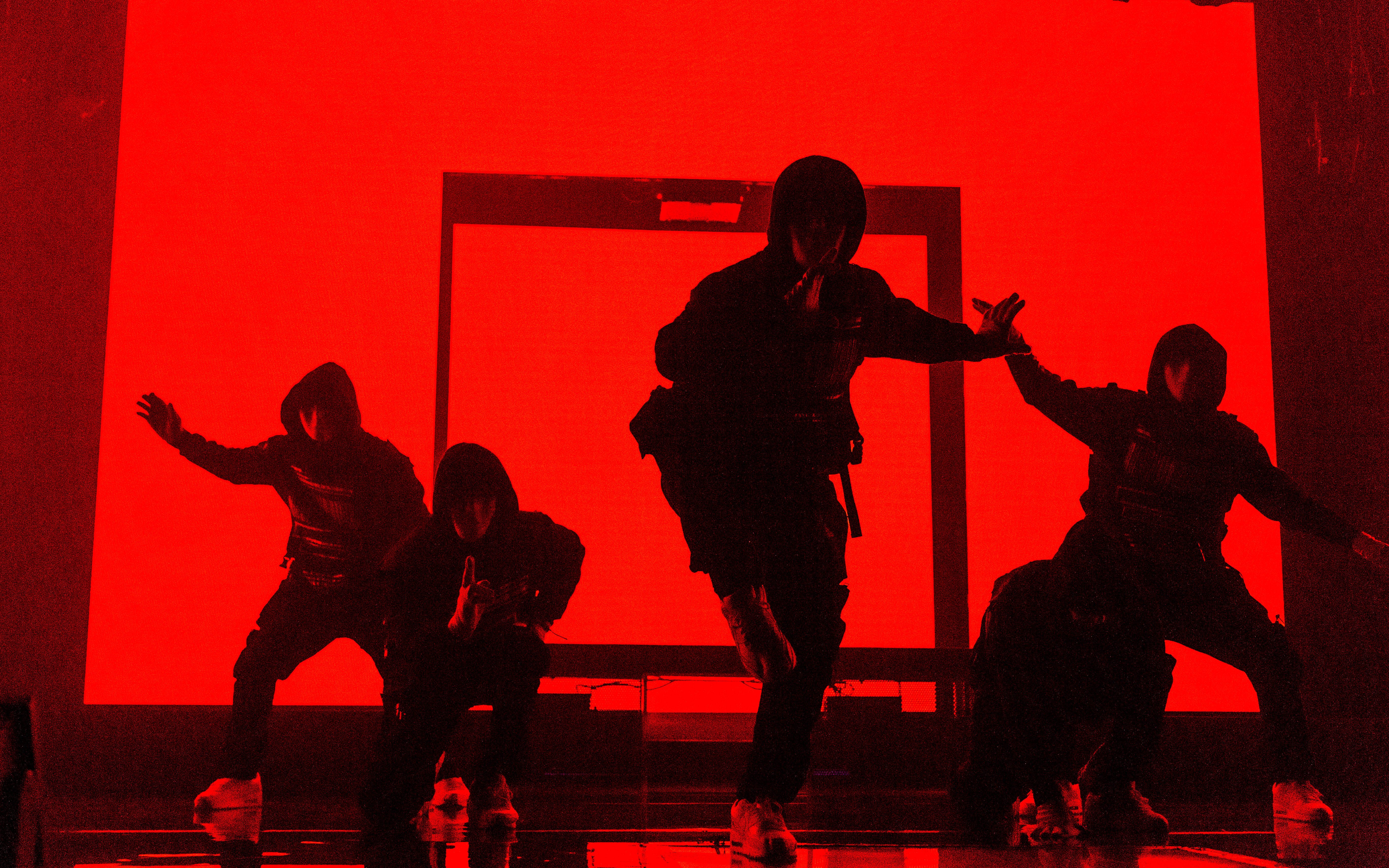 Dancers performing at Jabbawockeez show in Las Vegas with red backdrop.