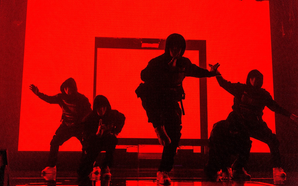 Dancers performing at Jabbawockeez show in Las Vegas with red backdrop.