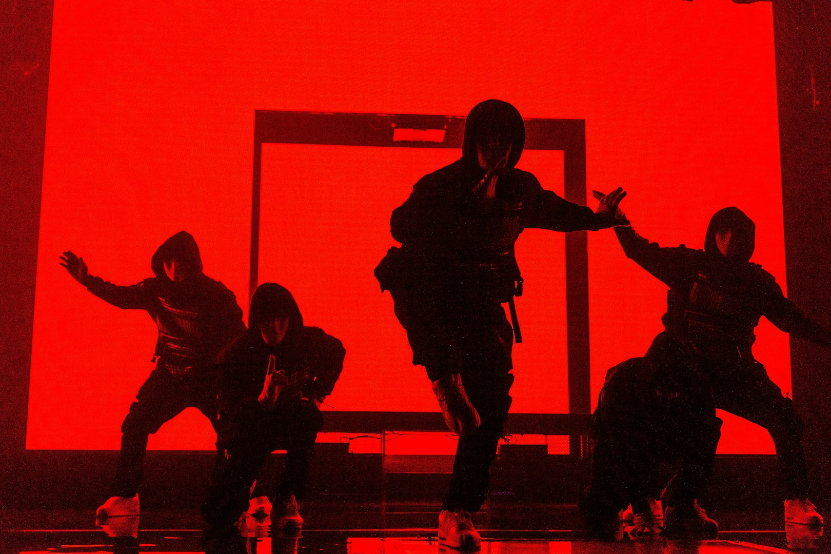 Dancers performing at Jabbawockeez show in Las Vegas with red backdrop.