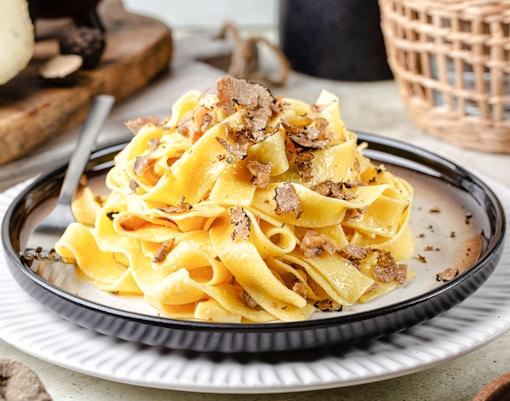 Truffle pasta dish at Delphi Restaurant with shaved truffles on a plate.