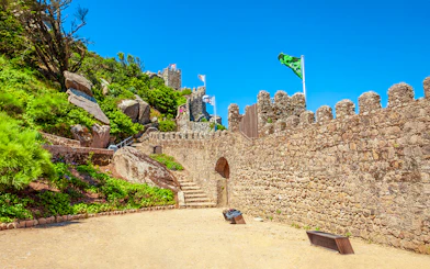 Moorish Castle gates with stone paths and flags in Sintra, Portugal.